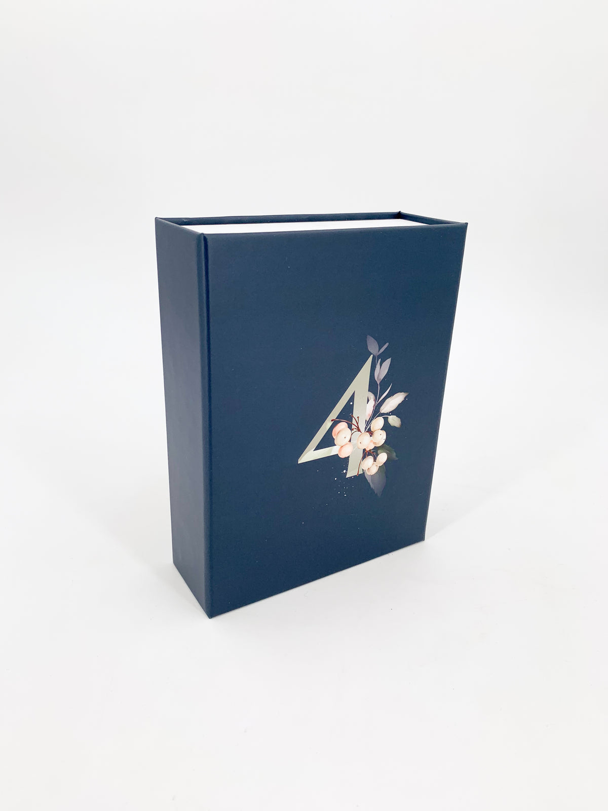 Eine blaue Magnetbox mit der Zahl 4 und kleinem dekorativen Pflanzen Print, hochkannt auf weißem Hintergrund