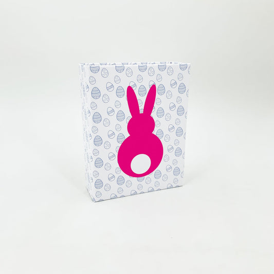 weiße geschlossene magnet schachtel mit pinkem hasen und kleinen ostereiern als motiv, weißer hintergrund