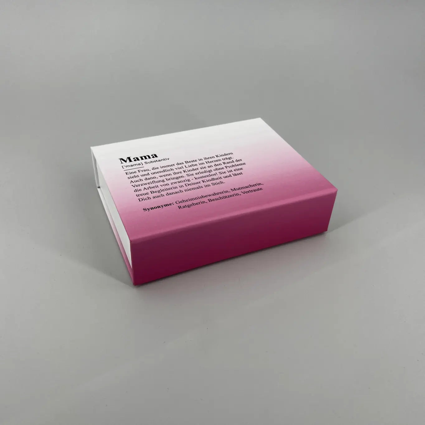 Weiß Pinke Schachtel mit Mama Definition als Print Motiv, liegend auf hellgrauem Hintergrund
