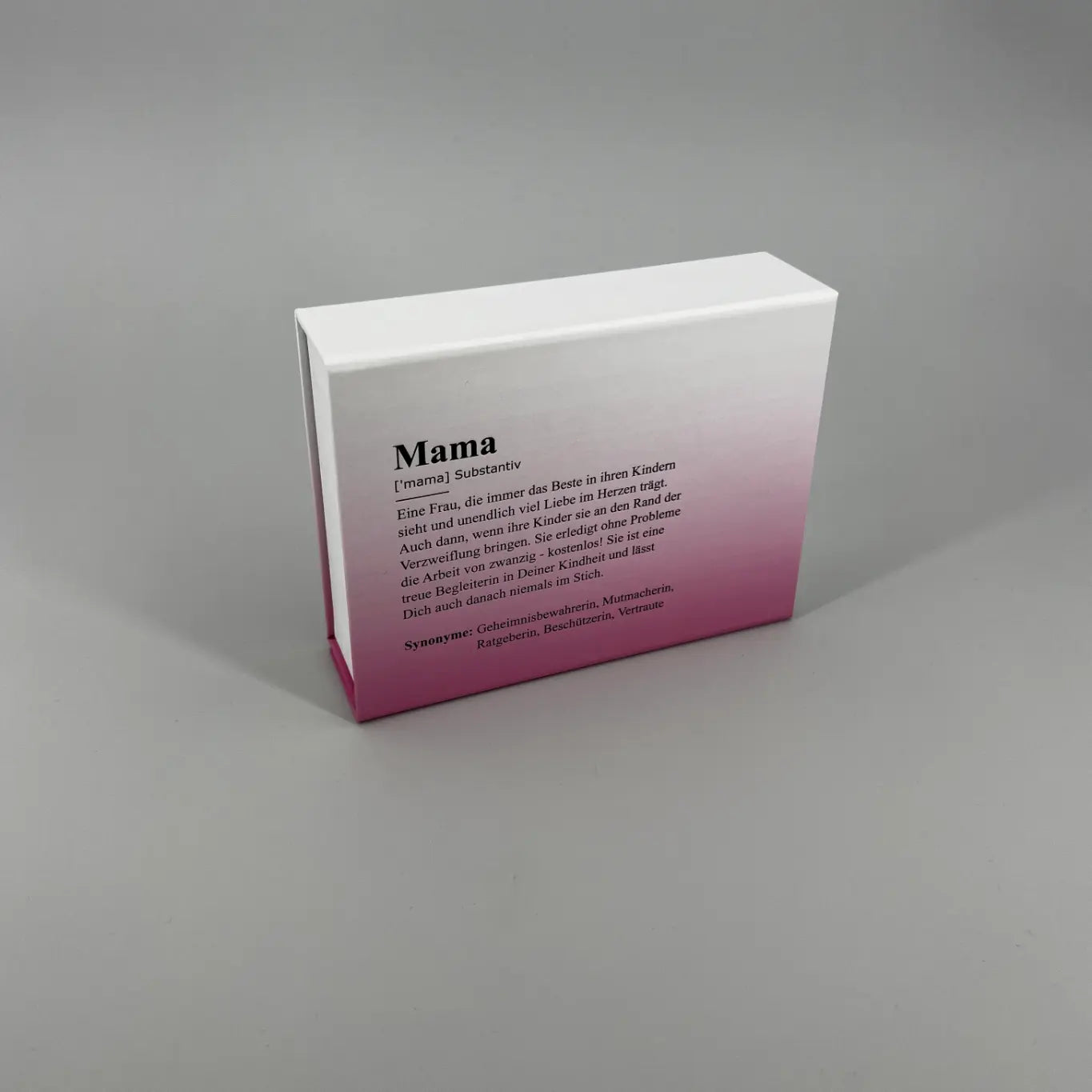 Weiß Pinke Schachtel mit Mama Definition als Print Motiv, stehend auf hellgrauem Hintergrund